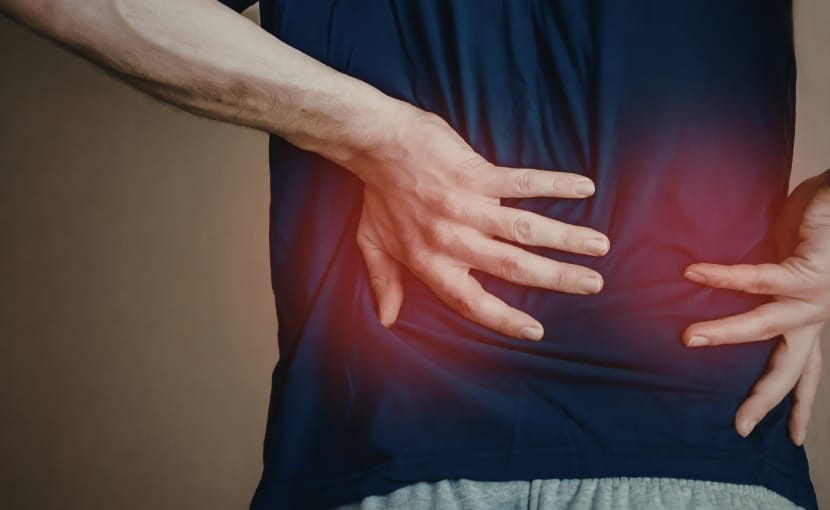 man holding lower back in pain